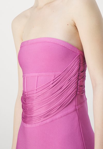 Strapless pink dress featuring ruched detailing on the side, smooth fabric texture, and a fitted silhouette.