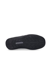 Schwarze Gummisohle mit strukturiertem Grip-Muster, das ein erhabenes Logo und glatte Kanten für verbesserte Haltbarkeit und Traktion aufweist.