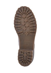 Suela de bota de caucho marrón con un diseño de banda de rodadura resistente que presenta patrones hexagonales y en forma de cruz para mejorar la tracción. Tacón plano, superficie texturizada.