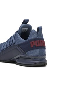 Scarpa sportiva blu con parte superiore in rete, colletto imbottito, ammortizzazione del tallone spessa e un logo rosso in rilievo sulla cinghia del tallone.