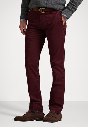Bordeaux chino's van katoen, met een slim fit, zijzakken en een bruine leren riem. Gecombineerd met bruine suède instappers.