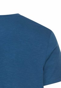 Achteraanzicht van een effen blauw T-shirt met korte mouwen, met details van de schouder en de bovenkant van de mouw, op een witte achtergrond.