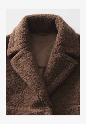 Brauner, strukturierter Mantel aus dickem, plüschigem Material. Verfügt über einen breiten Kragen und Vorderennähte. Weiche Innenverkleidung am Kragen sichtbar.