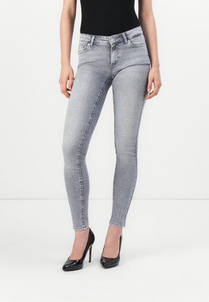 Grå skinny jeans laget av denim, med klassisk fem-lomme design og subtil fading, kombinert med svarte høye hæler.
