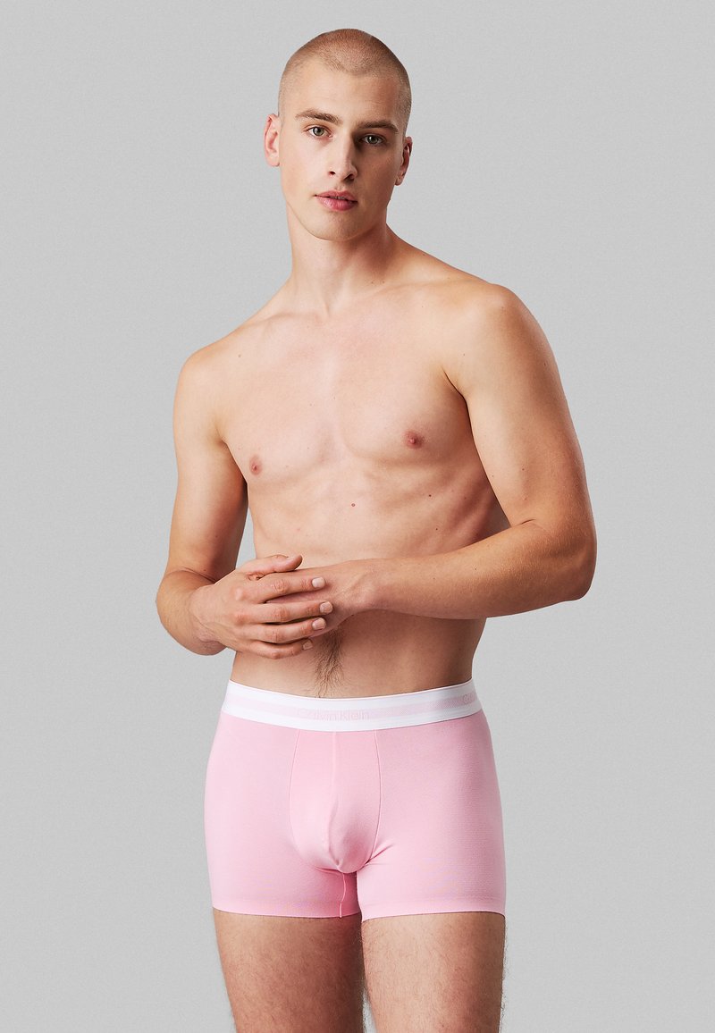 Boxer in rosa con un elastico bianco in vita che presenta il logo Calvin Klein. Tessuto morbido con un design aderente, lunghezza fino a metà coscia.