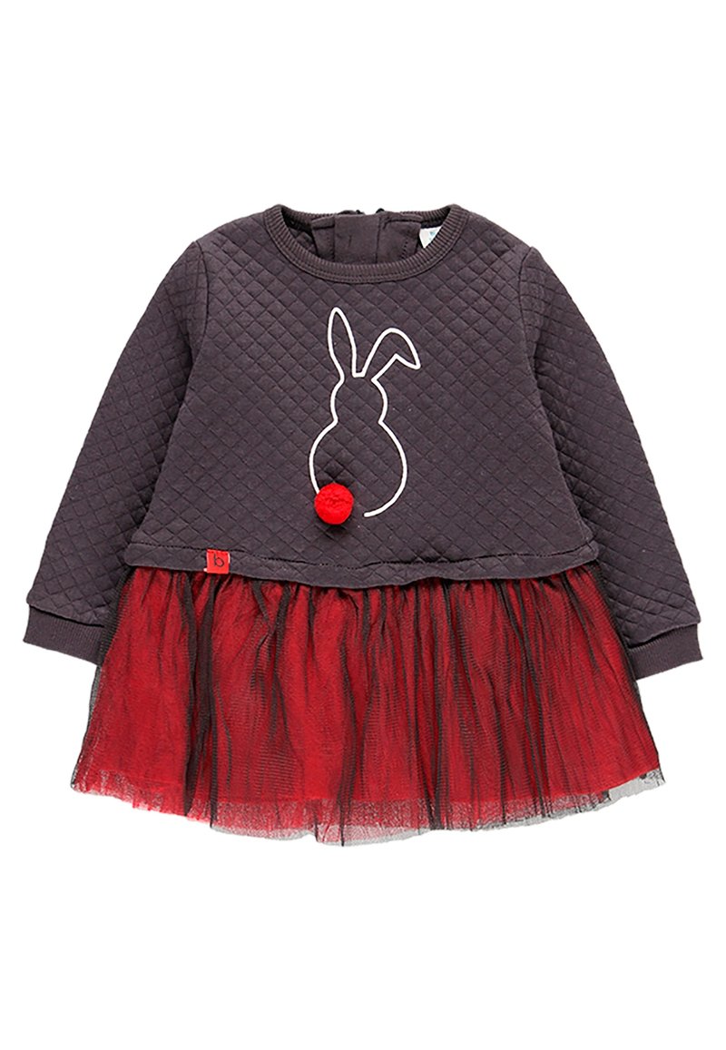 Długi rękaw, pikowana bluzka w ciemnoszarym kolorze z białym konturem królika i akcentem w postaci czerwonego pompona; warstwowa spódnica z czerwonego tiulu z czarną podszewką.