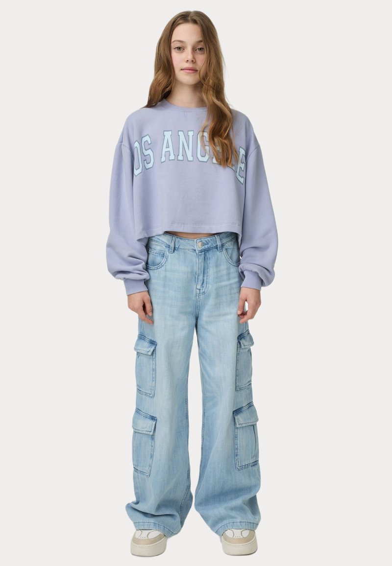 Klippd lavender sweatshirt med "LOS ANGELES" i ljusblå text, kombinerad med ljusblå cargobyxor med sidofickor och vida ben.
