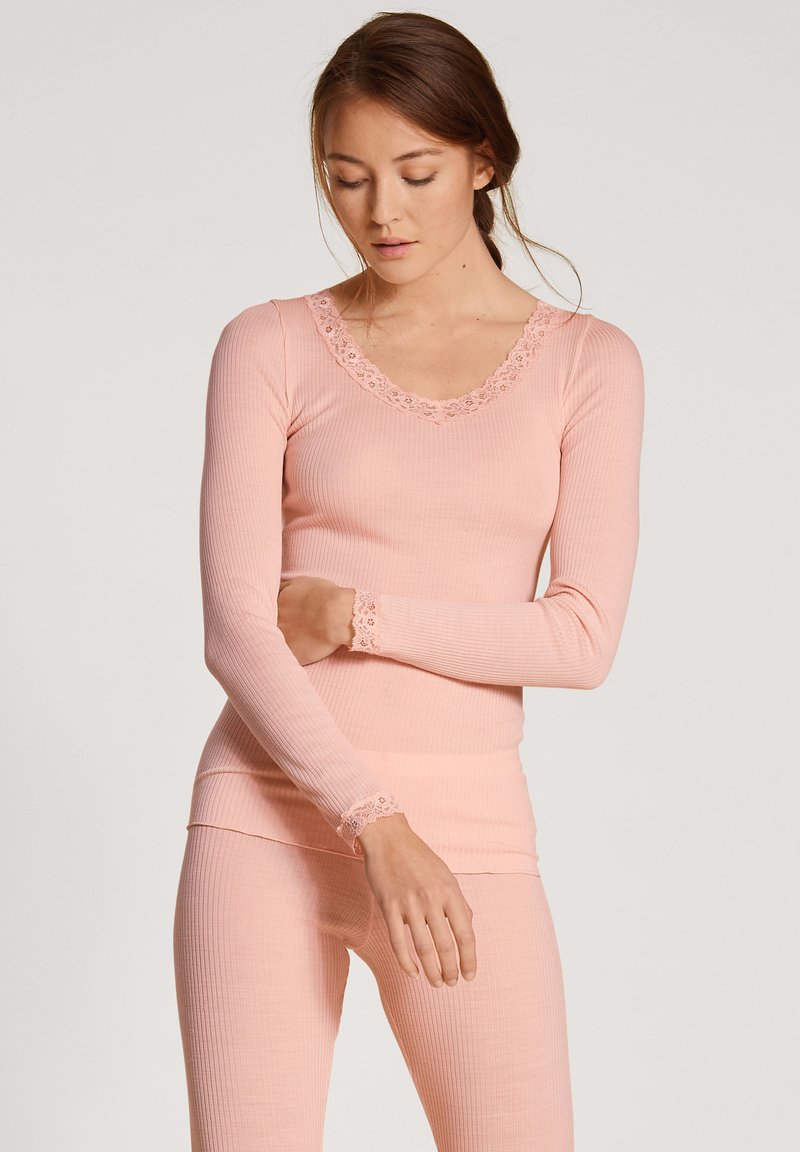 Langarm, ribfluwelen thermoshirt in zachtroze met een geschulpte kantenkraag en manchetten, gemaakt van een aansluitende rekbare stof.