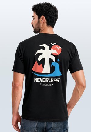 Man in black t-shirt with a graphic of a palm tree, sun, waves, red mountain, birds, and the word NEVERLESS on the back.