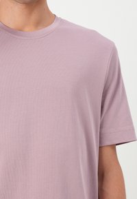 Svetlofialové tričko s krátkym rukávom, okrúhly výstrih, vyrobené z jemnej bavlny, s hladkou textúrou a minimalistickým dizajnom.