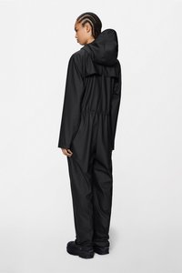 Mustast vettpidavast siledast kangast kombinesoon, millel on kapuuts, elastne vöökoht ja pikad varrukad, nähtud tagantpoolt.