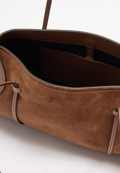 Καφέ τσάντα από σουέντ με λεπτό δερμάτινο λουράκι και ευρύχωρο μαύρο εσωτερικό θήκη.
