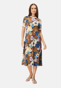 Ruskean kukkakuosiset mekko lyhyillä hihansuilla, jossa on monivärisiä kukkia sinisessä, vaaleanpunaisessa ja kermassa. Pehmeä kangas ja polvipituinen malli.