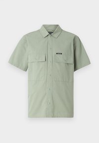Short-sleeve, light green shirt made of cotton, featuring a button closure and two front flap pockets with a branded label at the chest.
