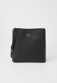Borsa a tracolla nera con esterno testurizzato, forma piatta, chiusura con zip e accento del logo argentato sul davanti. Incluso cinturino regolabile.