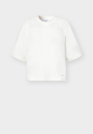 Biały T-shirt z krótkim rękawem i okrągłym dekoltem, z szerokimi rękawami oraz małym logo przy dolnym brzegu po prawej stronie.