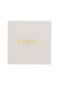 Parche de tela cuadrado blanco con la palabra "amor" en relieve dorado centrada en él.