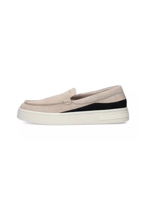 Zapato slip-on beige claro hecho de ante con un panel de acento negro. Presenta una suela blanca gruesa y un detalle de costura en la parte superior.