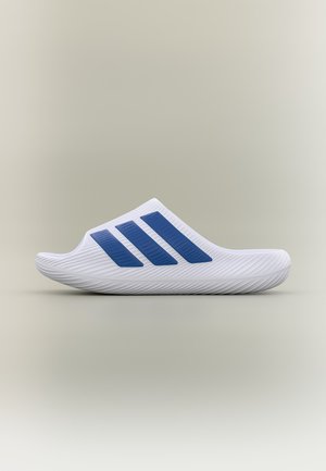 Άσπρο σανδάλι slip-on με υφασμένη σόλα και τρεις μπλε διαγώνιες γραμμές στην πλευρά σε ουδέτερο φόντο.