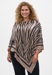 Poncho léger beige avec des rayures zébrées noires contrastantes, doté d'un large col et d'une coupe triangulaire, texture douce, et manches tombantes.