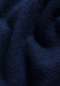 Marineblaues gewebtes Material mit einer weichen, flauschigen Textur, das subtile Nuancen in Farbton und Tiefe aufweist und somit ein reichhaltiges, mehrschichtiges Erscheinungsbild schafft.