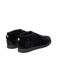 Paio di scarpe slip-on in velluto nero con sottili motivi floreali, piccoli brad selvatici neri e accenti rotondi dorati con logo sul retro.