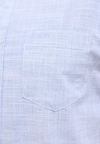 Jasnoniebieska, tkana koszula z naszywaną kieszonką o kwadratowym wzorze, teksturowanym materiale i subtelnym kratkowanym wzorze.