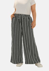 Randiga byxor med vida ben i svart och vitt, med dragsko i midjan, tillverkade av ett lättviktigt material, med två sidfickor.