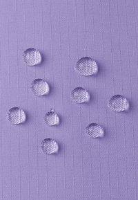 Lila strukturierte Oberfläche mit mehreren klaren Wassertropfen, die Licht reflektieren, in unterschiedlicher Größe und über den Stoff verteilt.