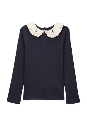 Haut à manches longues rayé bleu marine avec un col froncé blanc orné d'accents brodés. Fermeture à boutons au dos ; texture douce.