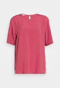 Rosa kortärmad blus med rund halsringning, nyckelhålsdetalj bak och sidslitsar. Tillverkad av ett mjukt tyg, den har en lös passform.