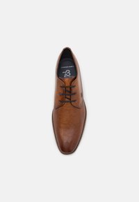 Scarpa eleganti in pelle marrone con superficie testurizzata, punta arrotondata, design con lacci e dettagli sull'etichetta interna.