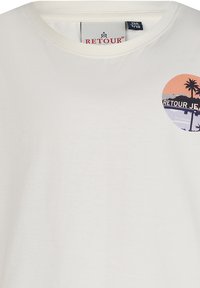 Biała bawełniana koszulka z okrągłym dekoltem, z wielokolorowym okrągłym nadrukiem palm i napisem "RETOUR JEANS."