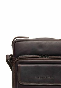 Borsa a tracolla in pelle marrone con molteplici scomparti con cerniera, superficie testurizzata e dettagli di cucitura sottili. Caratterizzata da un logo sul davanti.