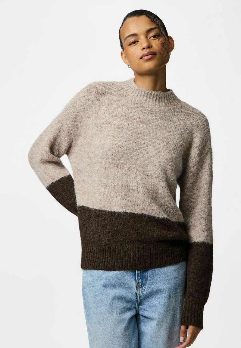 Pull en laine beige clair avec un ourlet et une partie inférieure marron foncé. Présente un col côtelé et des manches longues, mettant en valeur un tissu doux et texturé.