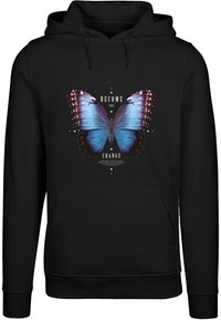 Haut à capuche noir avec un grand graphique de papillon bleu et le texte "DEVENIR LE CHANGEMENT" en blanc, entouré d'étoiles décoratives.