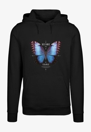 Mustikas sweatshirt, millel on suur sinine liblikas ja tekst "MUUTU MUUTUSEKS" valgete tähtedega kujunduse ümber.