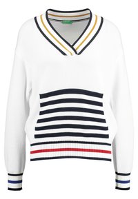 Vit stickad tröja med marinblå och gulrandig V-hals, med en lodrät randig ficka i marinblått, rött och vitt.