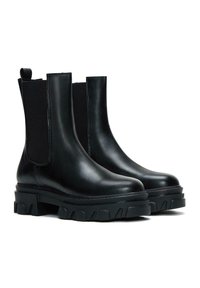 Bottes Chelsea en cuir noir avec des panneaux élastiques sur les côtés, des semelles en caoutchouc épaisses et une finition lisse. Comprend une languette en boucle pour un enfilage facile.
