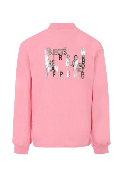 Różowa bluza z długimi rękawami z nadrukiem na plecach. Tekst brzmi: "OBIEKTY W LUSTERKU SĄ BLIŻEJ, NIŻ SIĘ WYDAJĄ."