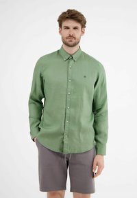 Lichtgroene, lange mouw overhemd met een button-down kraag, subtiele textuur en een klein logo op de borst, gecombineerd met grijze shorts.