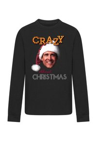 Must mustaheline särk, millel on graafiline kujundus: naeratav nägu Jõuluvana mütsiga, millel on heledates reklamitekstides kirjutatud "CRAZY" ning allpool "About CHRISTMAS".