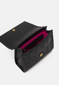 Borsa a mano nera in pelle con motivo a logo in rilievo, chiusura a scatto dorata e fodera interna rosa brillante, dotata di tasca con zip e scomparti per carte.