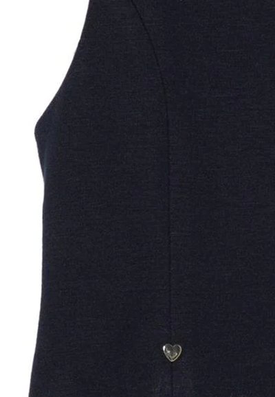 Haut sans manches bleu marine foncé avec une texture lisse, arborant un petit accent en forme de cœur argenté près de l'ourlet et des lignes épurées et simples.