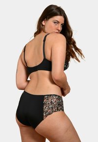 Ensemble de lingerie noire comprenant un soutien-gorge et une culotte taille haute. Le soutien-gorge possède des bretelles ajustables, tandis que la culotte met en valeur des accents en dentelle florale.