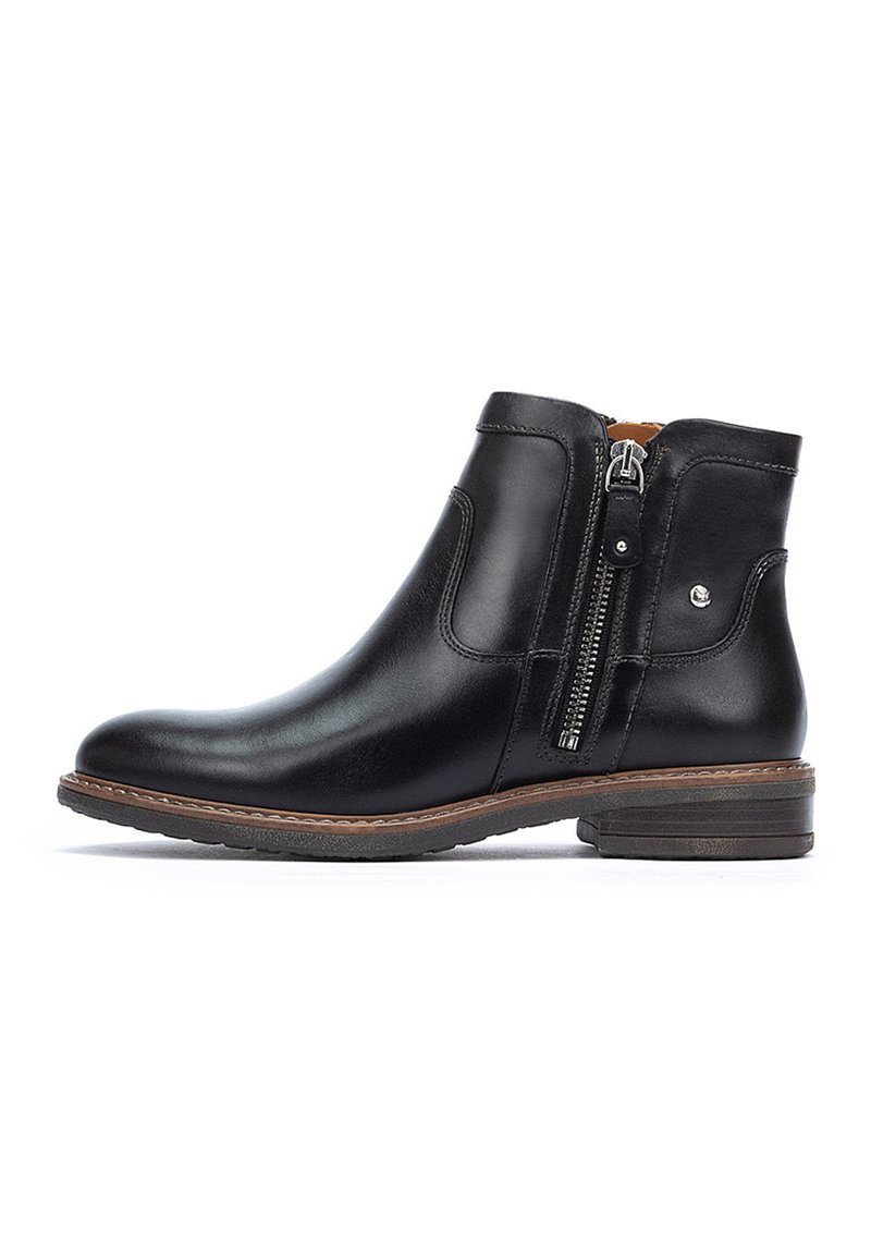 Bottine en cuir noir avec fermeture éclair sur le côté, bout arrondi, petit talon empilé et détails de couture marron contrastants. Texture lisse sur l'ensemble.