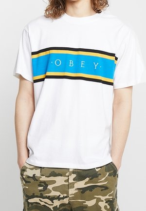 Weißes T-Shirt mit kurzen Ärmeln, das einen blauen, schwarzen und gelben horizontalen Streifen mit dem Text "OBEY" in der Mitte zeigt. Aus Baumwolle, entspannte Passform.