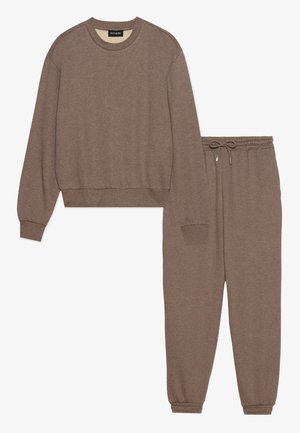 Sweatshirt marron et pantalon assorti en tissu doux. Le haut a un col rond et des poignets côtelés ; le pantalon dispose d'une taille élastique et de poignets élastiques.
