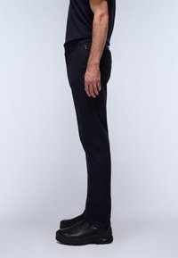 Mørkeblå bukser med slim fit og slankt design. Lavet af glat stof, med en standard talje og sidelommer. Sorte slip-on sko.