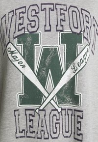 Šedé bavlněné tričko s centrálním grafikou: "WESTFORT LEAGUE" v tmavě fialové barvě s velkým "W" akcentovaným bílými vesly. Zničená textura.